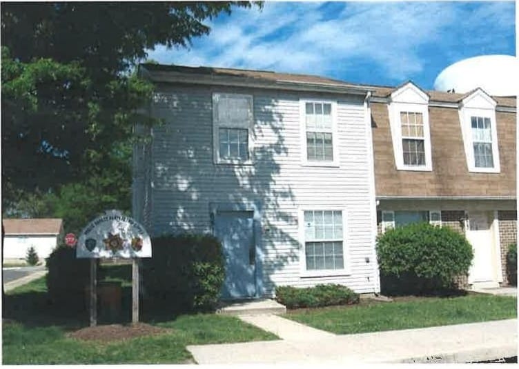 Two-story townhouses at Carroll LaPlata Village with light siding and brick, and tidy landscaping